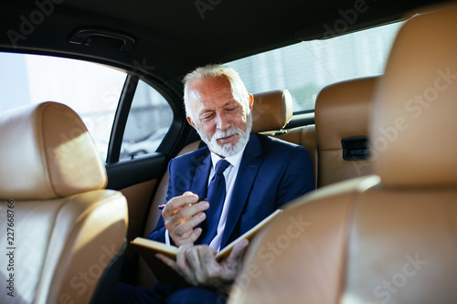 Senior business man sitting in his limousine. Business concept. Back light. © hedgehog94