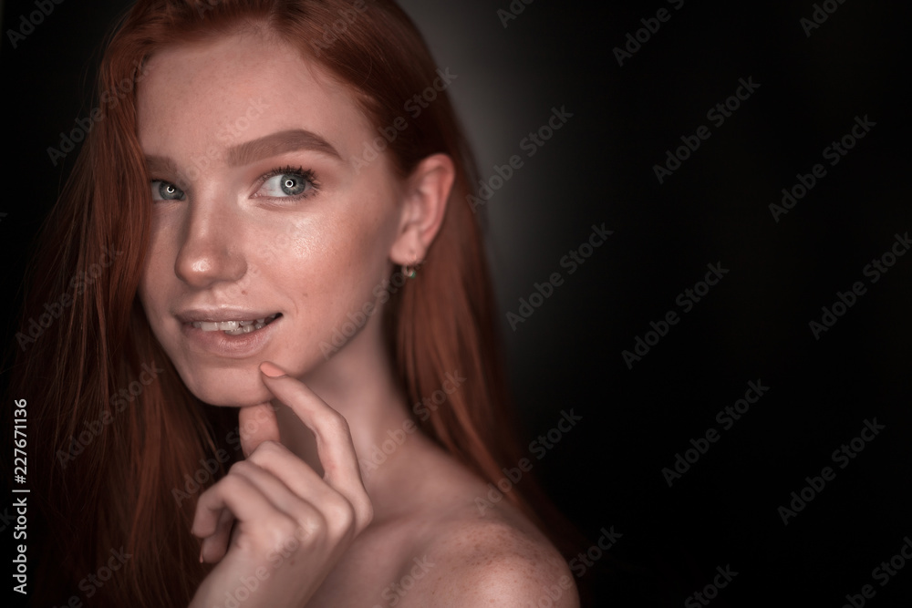 Thinking dreaming redhead girl woman with healthy glow wet skin posing isolated over black wall background looking aside to empty copyspace biting lip. Thinking dreaming redhead girl woman with healthy glow wet skin posing isolated over black wall background looking aside to empty copyspace biting lip.