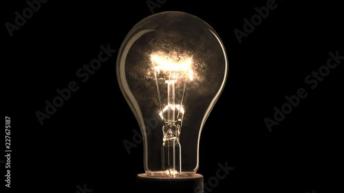 Realistic light bulb blinking on black background.