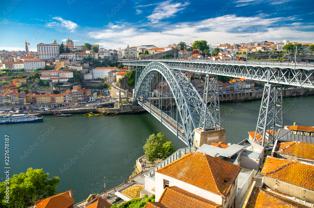 Aerial view of Ponte Luis Bridge over Douro River, tiled roofs of colorful buildings and old historic district Ribeira in Porto Oporto city, Portugal