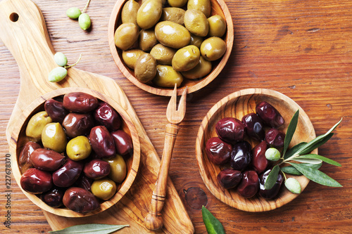 Natural greek olives in bowls with kitchen board from olive tree from above.