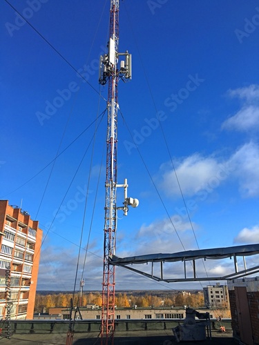 cell tower on the roof of the building against the blue sky