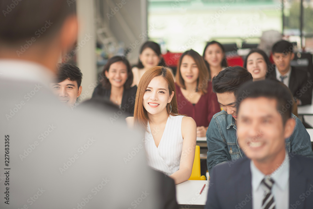Man speaker talking in front of seminar meeting room with many audiences for business Man speaker talking in front of seminar meeting room with many audiences for business