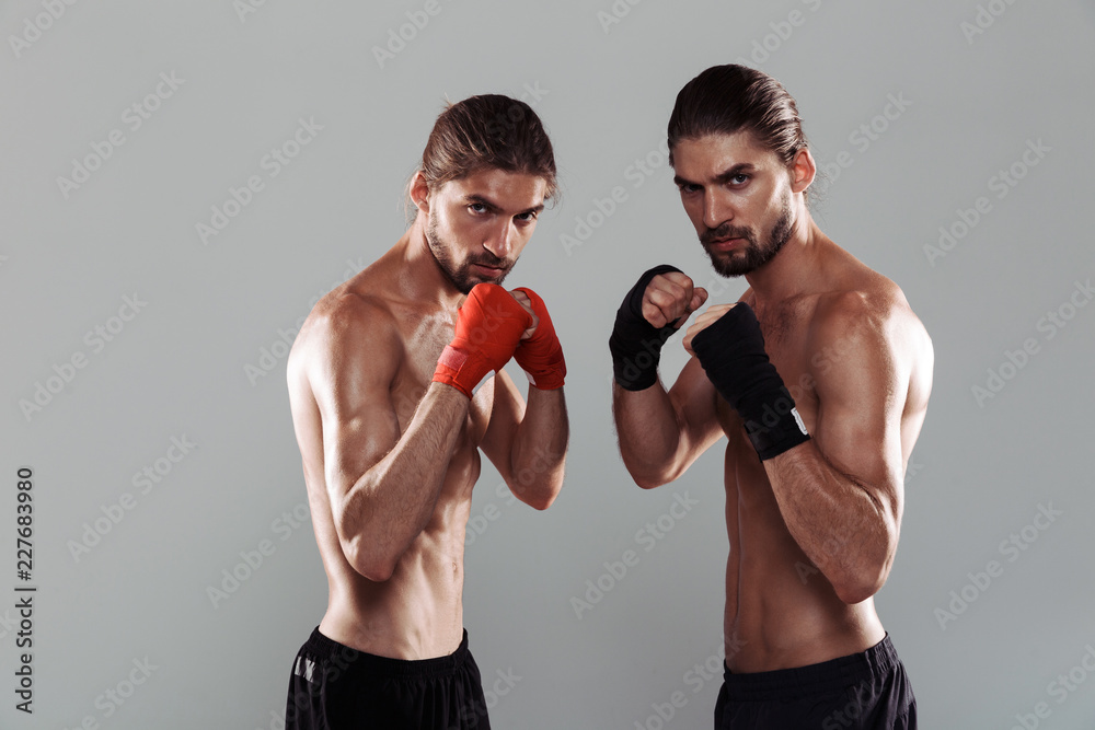 Portrait of a two confident muscular shirtless twin brothers Portrait of a two confident muscular shirtless twin brothers