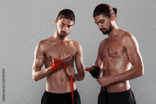 Portrait of a two muscular shirtless twin brothers