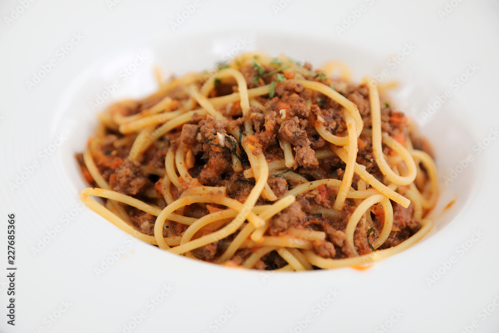 spaghetti Bolognese with minced beef and tomato sauce garnished with parmesan cheese and basil , Italian food