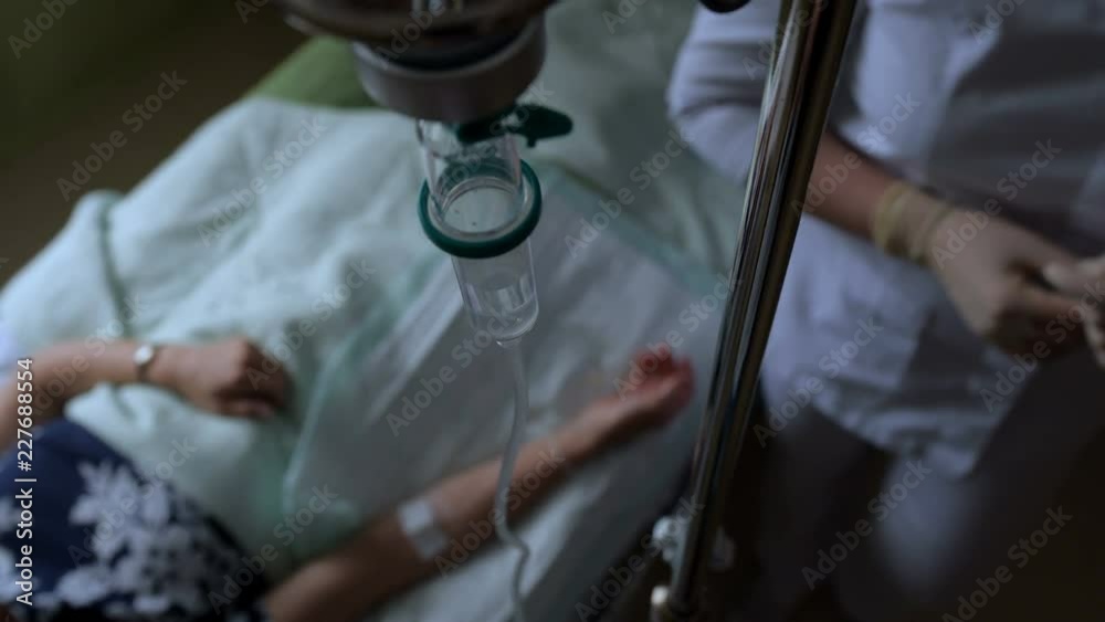The patient lies in a dark ward with a dropper. The patient lies in a dark ward with a dropper.