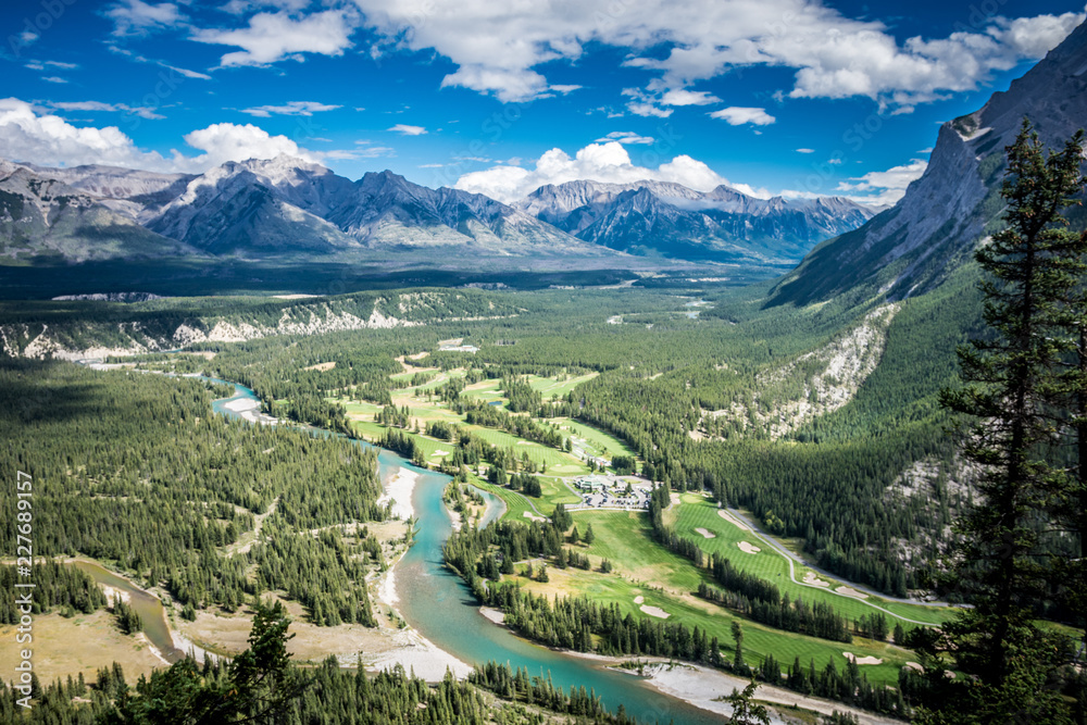 Lovely view from Tunnel Mountain summit in Banff National Park in Alberta Canada shows the Bow Valley below with its lush trees and a winding Bow River