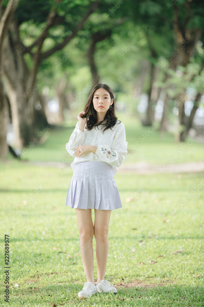 portrait of asian girl with white shirt and skirt looking in outdoor nature vintage film style portrait of asian girl with white shirt and skirt looking in outdoor nature vintage film style