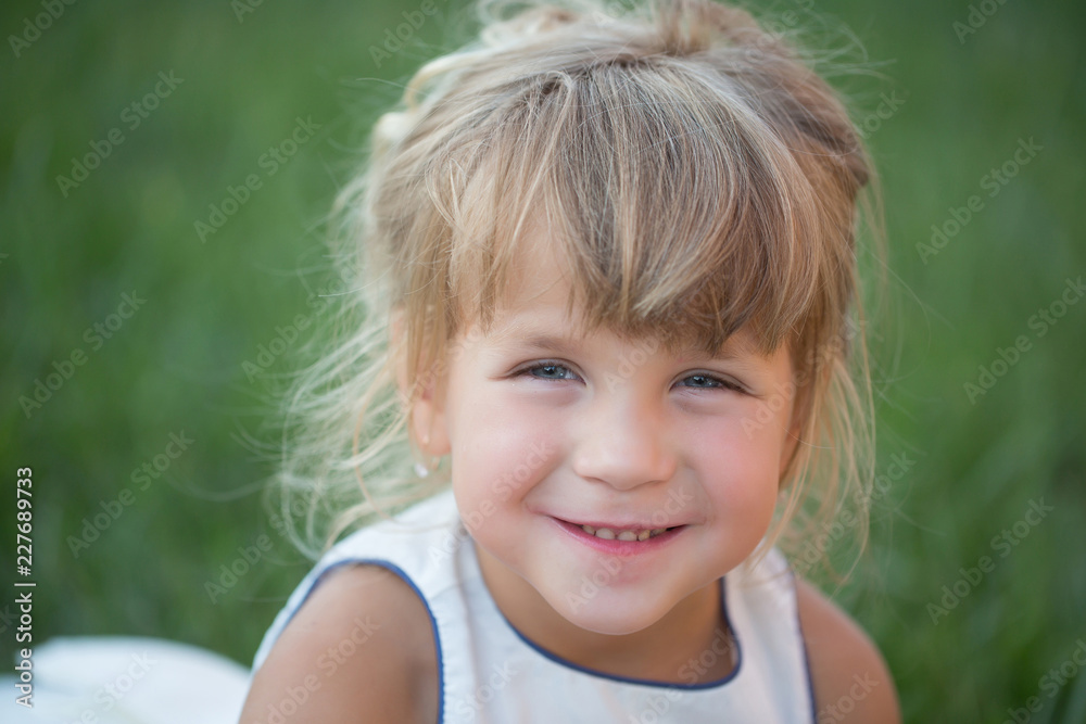 Girl with blond hair smile on green grass Girl with blond hair smile on green grass