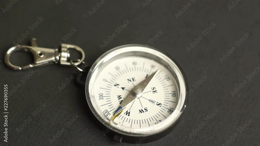 Female hand puts a compass on the table Female hand puts a compass on the table