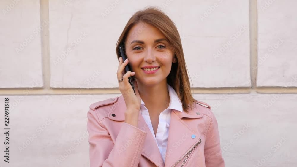 Portrait of young laughing woman talking on mobile phone Portrait of young laughing woman talking on mobile phone