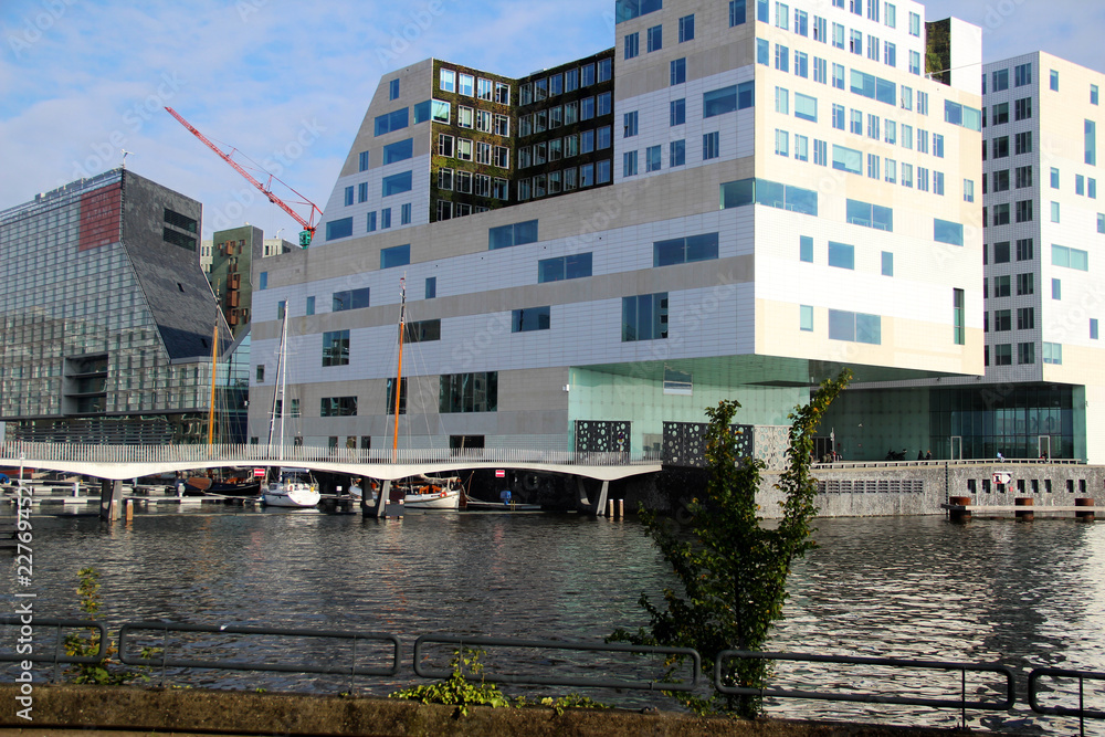 Naklejka premium blick auf ein modernes gebäude im hafen in amsterdam niederlande fotografiert während einer sightseeing tour in amsterdam niederlande