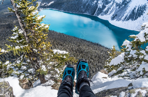 Winter boots hanging over blue glacial lake.