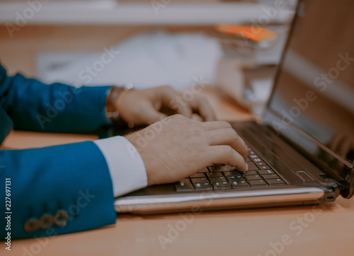 a man typing on a laptop, a businessman at a laptop (brown tinted)