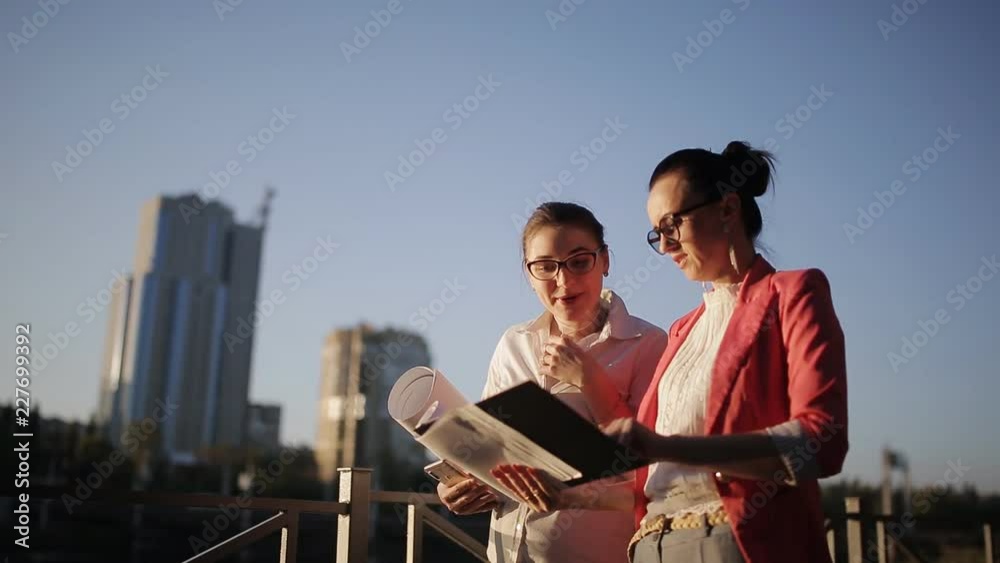 Two women with the drawings and technical documentation on the