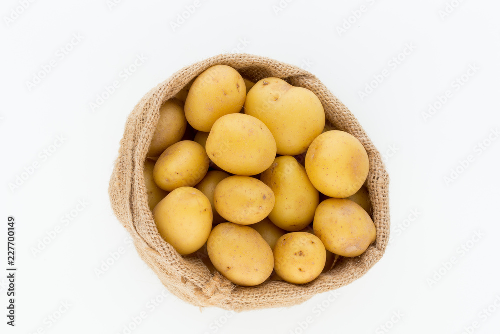 Sack of fresh raw potatoes on wooden background, top view Sack of fresh raw potatoes on wooden background, top view