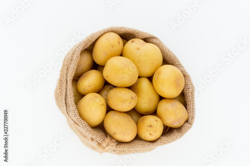 Sack of fresh raw potatoes on wooden background  top view