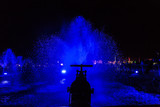 Woda tryskająca z rur w zbiorniku podświetlona niebieskim światłem