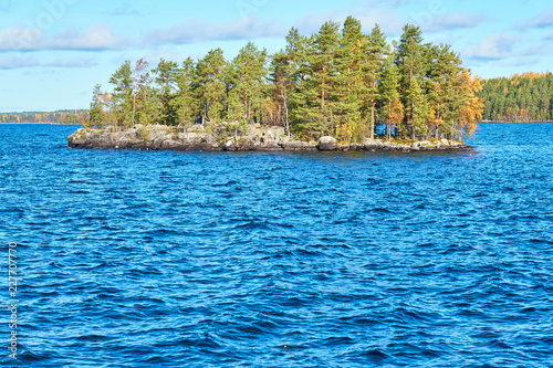                             Island on lake with autumn trees and autumn forest on the background. Copy space.   