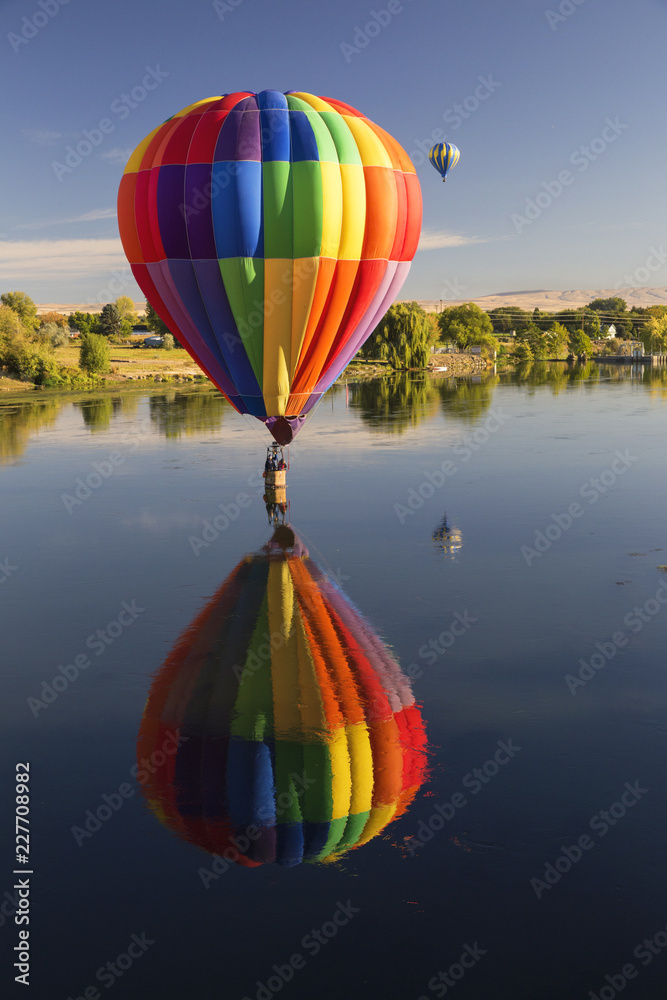Hot air balloons flying over still water