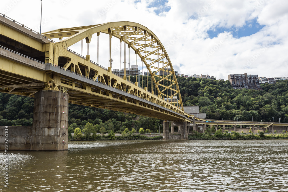 Large yellow bridge crossing calm river