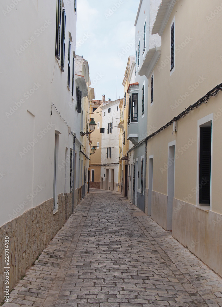 a typical narrow cobbled street of traditional painted houses in ciutadella menorca