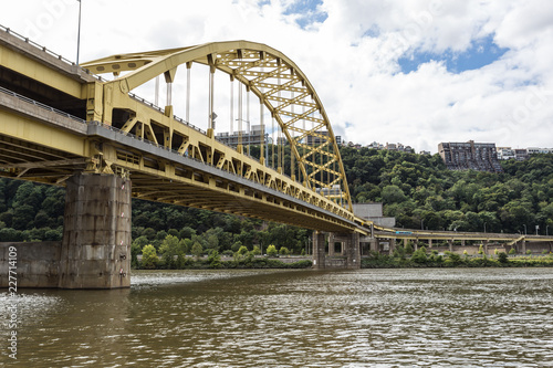 Large yellow bridge crossing calm river