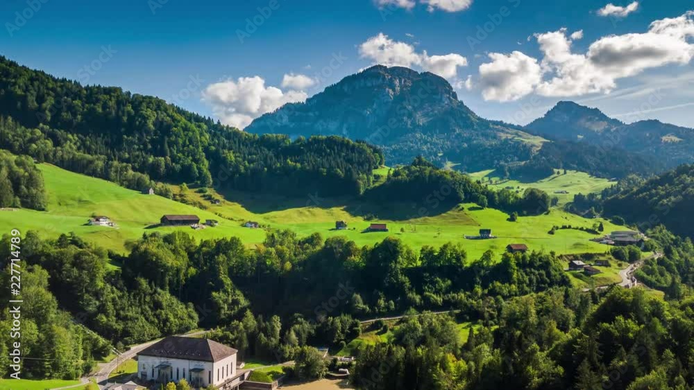 Beautiful drone hyperlapse taken on a sunny day in the summer. Some clouds are passing by. The camera moves towards the mountain.