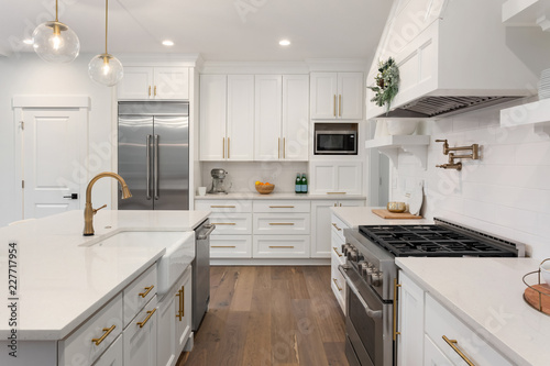 Beautiful kitchen detail in new luxury home. Features island, pendant lights, hardwood floors, and stainless steel appliances photo