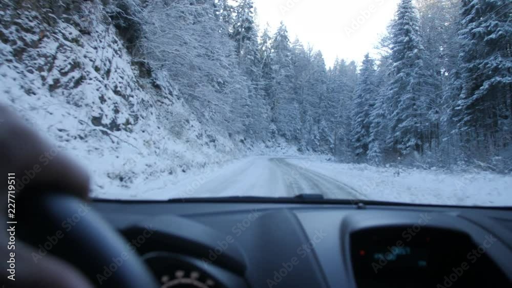 Driving on Slipper Snow Covered Road During Winter. Shot Through Windshield on Driver's Side and Dash Showing. Snow Covered Trees Lined the Sides of Road Indicating Cold Temperatures Driving on Slipper Snow Covered Road During Winter. Shot Through Windshield on Driver's Side and Dash Showing. Snow Covered Trees Lined the Sides of Road Indicating Cold Temperatures