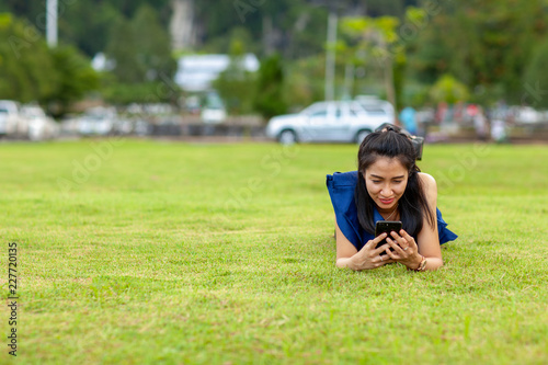 young asian woman lie on your stomach and using smart phone © Eakkapon Sriharun
