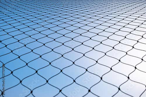 Net pattern rope silhouette against blue sky background.