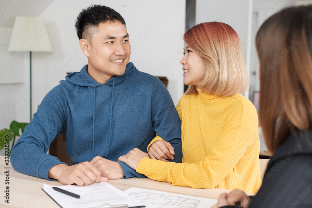 Asian happy couple buying new home with realtor agent with smiling face at new home.buying new house real estate. Asian happy couple buying new home with realtor agent with smiling face at new home.buying new house real estate.