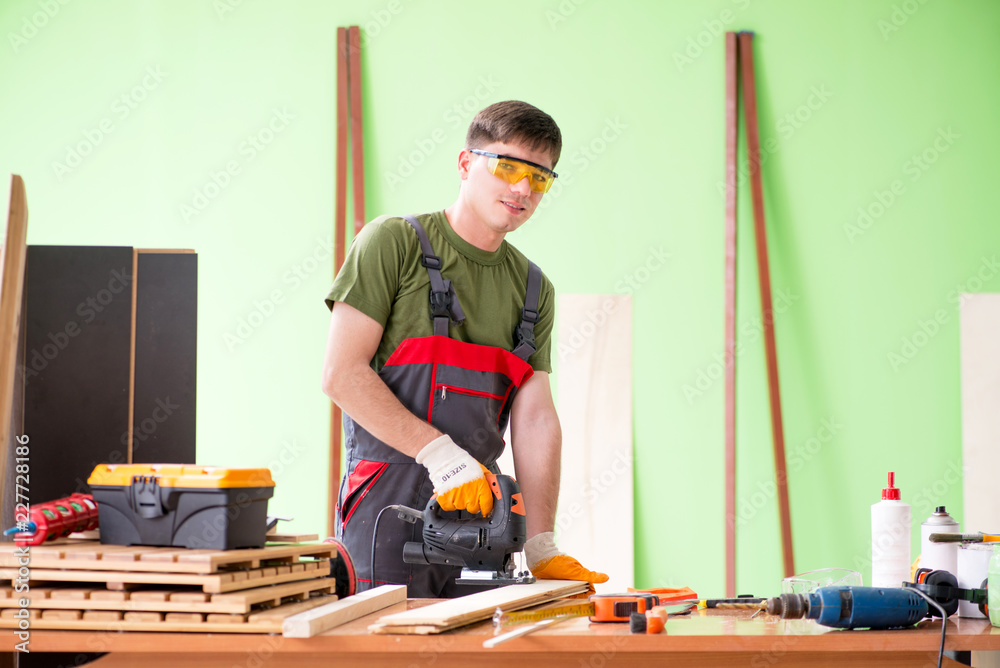 Young man carpenter working in workshop 