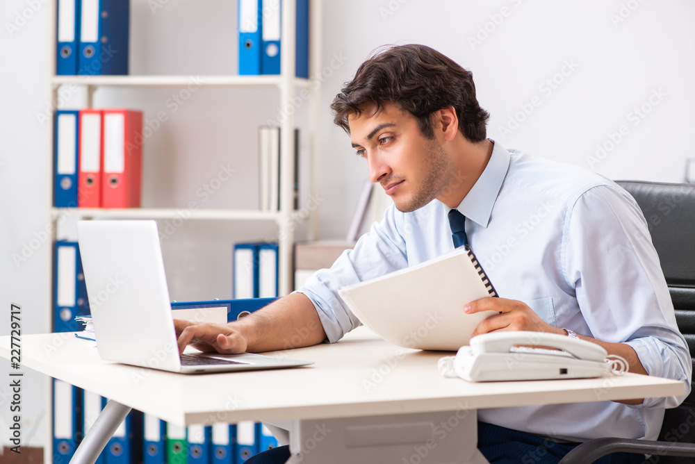 Young handsome businessman working in office Young handsome businessman working in office