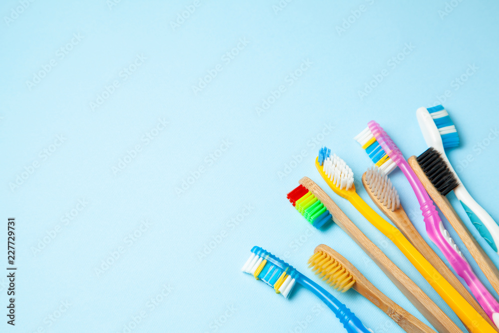 Many colored toothbrushes on blue background. How to choose toothbrush Many colored toothbrushes on blue background. How to choose toothbrush