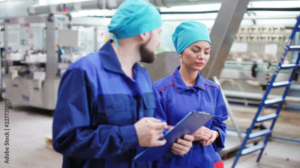 Worker with a clipboard inspects the plant Worker with a clipboard inspects the plant