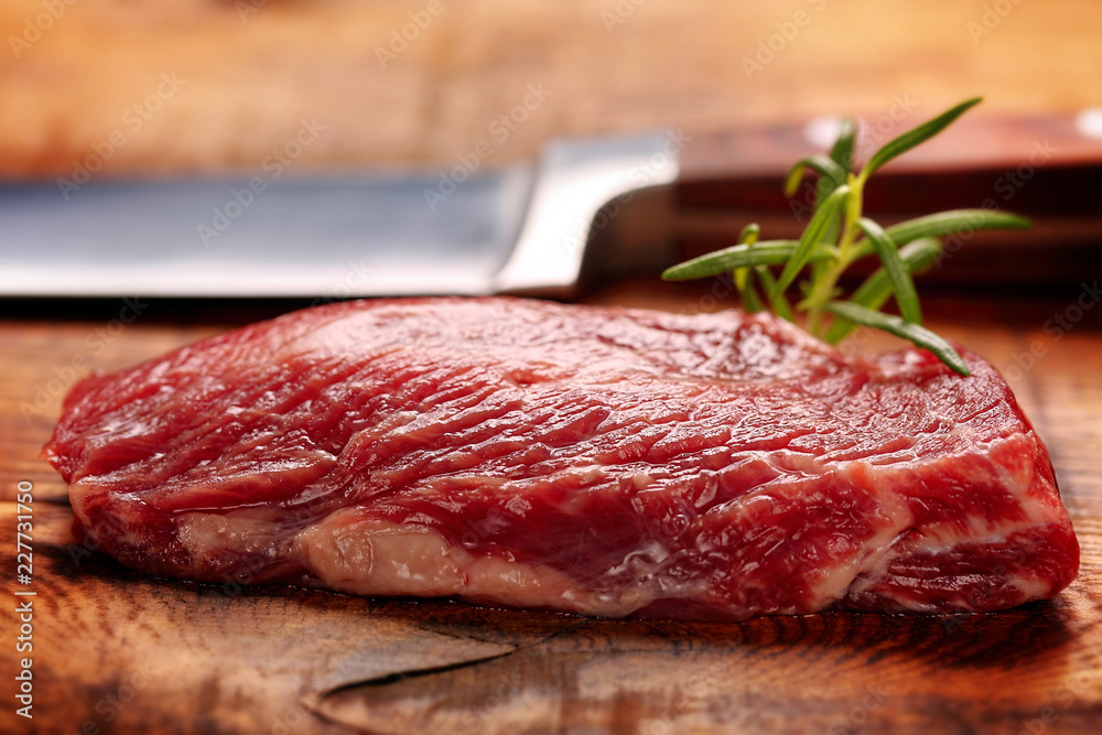 Raw slices beef steak on wooden background