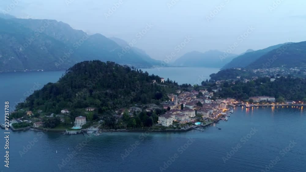 View from height Landscape in twilight time,circle around cape with illuminated town and mountains and lake around at background. Bellagio, Italy View from height Landscape in twilight time,circle around cape with illuminated town and mountains and lake around at background. Bellagio, Italy