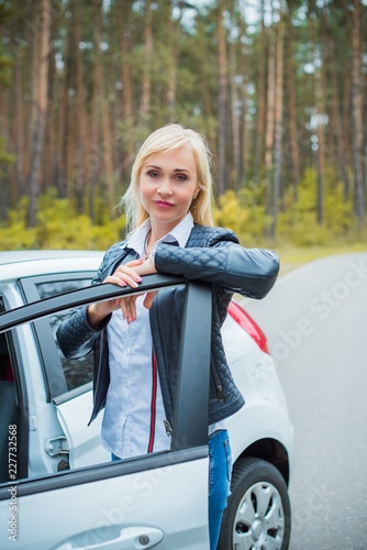 European mature elegant woman and car, lady driving automobile, outdoors portrait. Middle age woman driving on road, trip on beautiful autumn day. Concept of women and auto   © T.Den_Team
