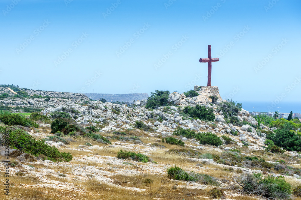 Wooden cross on a stone hill