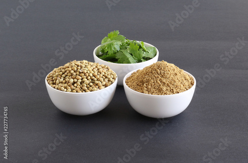 Coriander powder with coriander seeds and leaves, which are healthy food, in bowls.