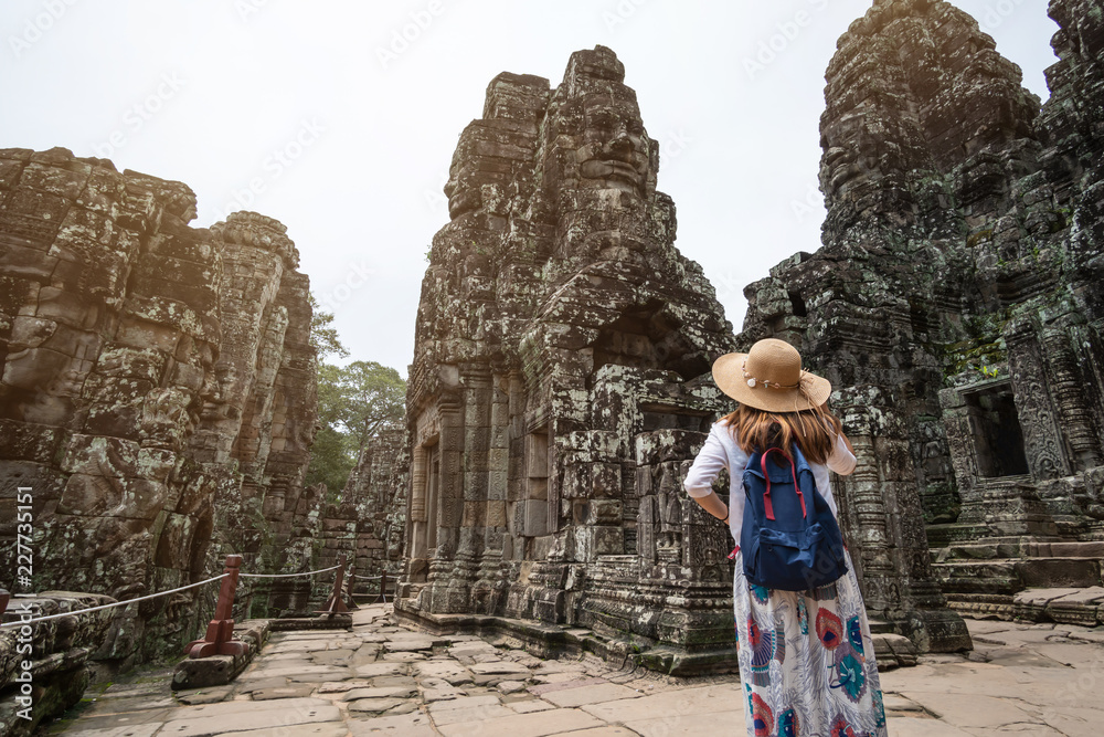 Fototapeta premium Młoda podróżniczka odwiedzająca świątynię Bayon w kompleksie Angkor Wat, dziedzictwo architektury khmerskiej w Siem Reap w Kambodży