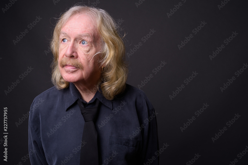 Senior businessman with mustache against gray background