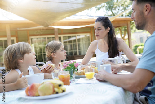 Family having breakfast in summer morning