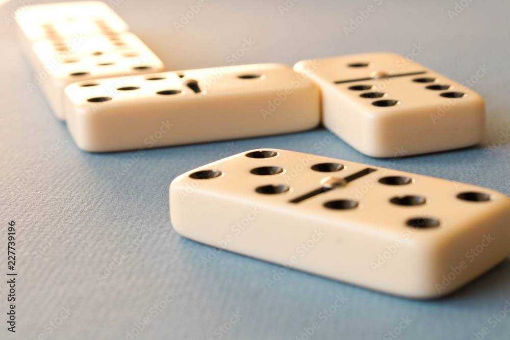 Playing dominoes on a blue background . Domino concept Playing dominoes on a blue background . Domino concept