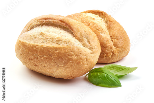 Freshly baked crispy bread rolls with basil leaves, close-up, isolated on a white background.