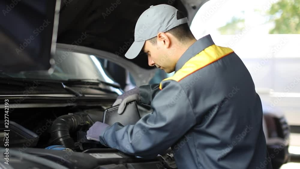 Mechanic pouring oil into a truck engine Mechanic pouring oil into a truck engine