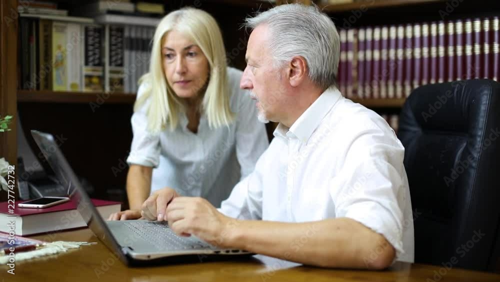 Manager talking to his secretary about financial charts Manager talking to his secretary about financial charts